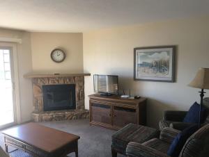 a living room with a television and a fireplace at Lake Condo with Heated Pool and Hot Tub at Lake Ozark in Osage Beach