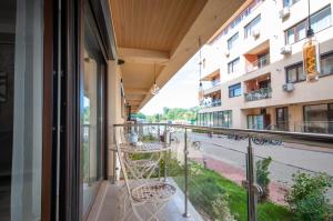 a balcony with a table and chairs looking out onto a street at Snagov Lake Apartments - Club Lac Snagov in Turbaţi