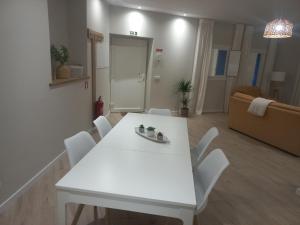 Biały stół i krzesła w salonie w obiekcie Casinha de Santo Amaro w mieście Ourém