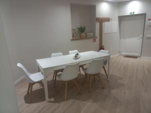Biały stół i krzesła w pokoju w obiekcie Casinha de Santo Amaro w mieście Ourém