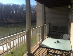 a screened porch with a table and chairs on a river at Condo with Pool and Hot Tub at Lake Ozarks in Osage Beach