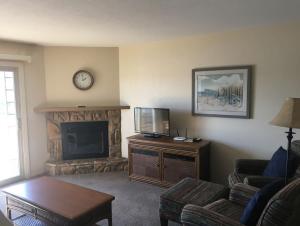 sala de estar con TV y chimenea en Condo with Outdoor Pool and Indoor Hot Tub and close to Grand Glaize Bridge at Lake Ozarks en Osage Beach