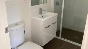 a bathroom with a toilet and a sink and a shower at Highway Tourist Village in Narrabri