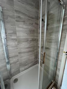 a shower with a glass door in a bathroom at Comfortable Double Bed in Coventry