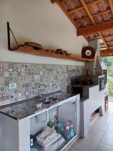 a kitchen with a sink and a counter at Chale Jatoba Monteiro Lobato in Monteiro Lobato