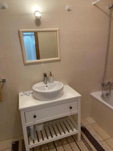 a bathroom with a sink and a mirror and a tub at Maura's Holiday House in Silveira