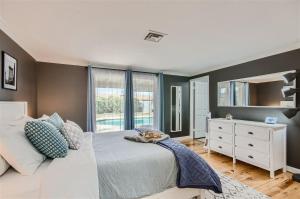 a bedroom with a bed and a dresser and a mirror at Arizona Daydream with Private Pool plus EV Charger in Chandler +20 photos