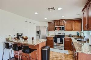 a kitchen with wooden cabinets and stainless steel appliances at Arizona Daydream with Private Pool plus EV Charger in Chandler