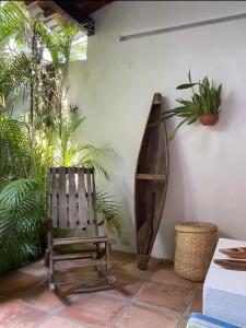 a wooden chair sitting in a room with plants at Casa colonial en el exclusivo Alto del Rosario in Honda