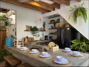 a kitchen with a counter with dishes and a refrigerator at Casa colonial en el exclusivo Alto del Rosario in Honda