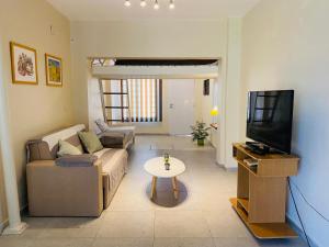 un soggiorno con un divano e una TV di Soleado Pampa a Santa Rosa