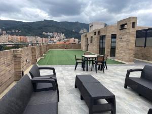 un patio con mesa y sillas en la azotea en Serenity Near Country Club - Loft Retreat, en Bogotá