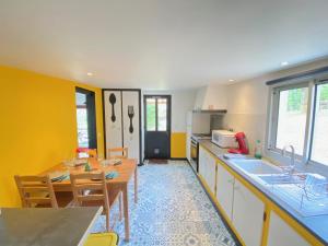 eine Küche mit einem Tisch und einem Esszimmer in der Unterkunft Gîte les chênes verts - Périgord noir in Saint-Amand-de-Coly