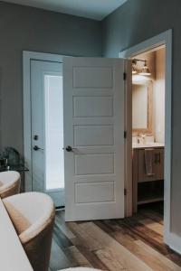 a bathroom with a white door and a sink at Winner's Circle in The City in Lexington