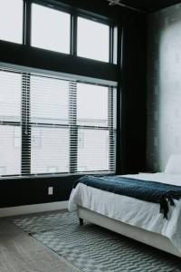 a bedroom with a bed and two large windows at Winner's Circle in The City in Lexington