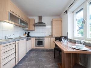 eine Küche mit Holzschränken und einem Holztisch in der Unterkunft Chalet Stitzgassl in Hopfgarten im Brixental