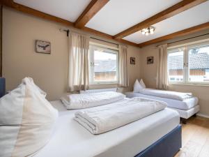 2 Betten in einem Zimmer mit 2 Fenstern in der Unterkunft Chalet Stitzgassl in Hopfgarten im Brixental