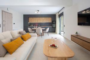 a living room with a white couch and a table at Pomaria Boutique Residences in Lefkada +54 photos