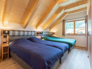 two beds in a room with wooden ceilings at Haus Rapunzel in Donnersbachwald