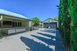 una sombra de una cerca en una acera al lado de un edificio en Darling St - Charming CBD Abode, Pet Friendly, en Dubbo