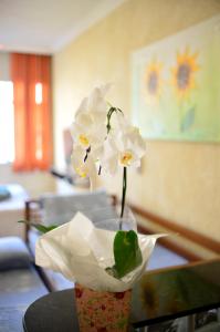 a vase with white flowers sitting on a table at Vista Mar Luxo Copacabana in Rio de Janeiro