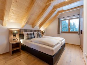 a bedroom with a large bed with a wooden ceiling at Traumhaus in Donnersbachwald