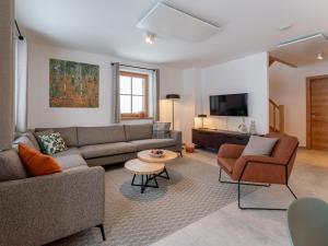 a living room with a couch and chairs and a tv at Haus Enzian in Donnersbachwald