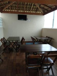 uma sala com duas mesas e cadeiras e uma televisão em Apto. inteiro c/ Piscina no Portal Ipês Cajamar SP em Cajamar