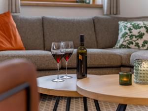 a bottle of wine and two glasses on a table at Haus Enzian in Donnersbachwald