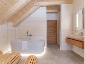 a white bathroom with a tub and a sink at Haus Enzian in Donnersbachwald