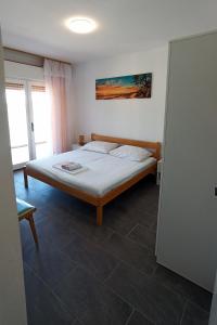 a bedroom with a bed in a room at Apartments by the sea Supetarska Draga - Donja, Rab - 5042 in Supetarska Draga