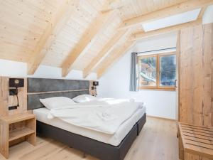 uma cama num quarto com tecto em madeira em Steier Hütte S em Donnersbachwald