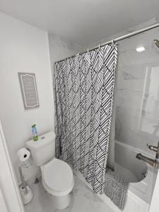Un baño con inodoro y cortina de ducha. en Niagara Shoreline Villa 2, en Tonawanda