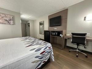 a hotel room with a bed and a desk and a tv at Red Roof Inn Richmond, VA - W Broad St in Richmond
