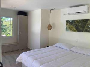 een witte slaapkamer met een bed en een raam bij Marbella Forest Retreat apartment 1bed, 2ppl in Santa Cruz