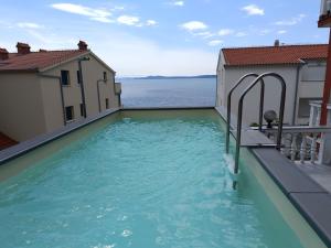 uma piscina com vista para a água em Seaside apartments with a swimming pool Businci, Ciovo - 11232 em Trogir