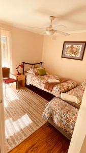 a bedroom with two beds and a ceiling fan at Mount Hope Estate Vineyard in Dixons Creek