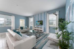 ein Wohnzimmer mit blauen Wänden und einem weißen Sofa in der Unterkunft Vibrant 6BR w Private Pool Grill by Disney in Davenport