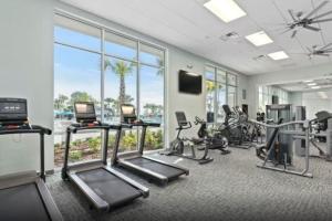 a gym with cardio equipment and a large window at Luxurious New 9BR Villa w Game Room Theater Pool in Davenport