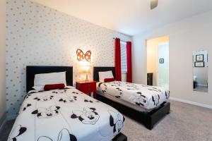 a bedroom with two beds with black and white sheets at Gorgeous 7BR Villa w Pool Games Resort Access in Kissimmee