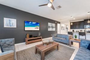 a living room with two blue couches and a tv at Gorgeous 7BR Villa w Pool Games Resort Access in Kissimmee