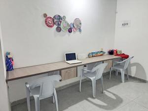 a room with a desk with a laptop and chairs at Refugio, Casa de la Playa in Manaure