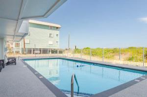 a large swimming pool in front of a building at Carolina Surf - 3BR Condo with Stunning Ocean Views in Carolina Beach
