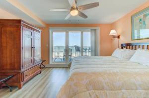 a bedroom with a bed and a ceiling fan at Carolina Surf - 3BR Condo with Stunning Ocean Views in Carolina Beach +31 photos