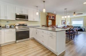 a kitchen with white cabinets and a counter top at Carolina Surf - 3BR Condo with Stunning Ocean Views in Carolina Beach