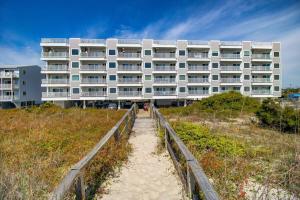 a building on the beach in front of a building at Carolina Surf - 3BR Condo with Stunning Ocean Views in Carolina Beach