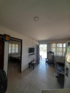 a living room with a couch and a tv at Jilymar Cabaña de descanso, Isla de Barú - Cartagena in Santa Ana