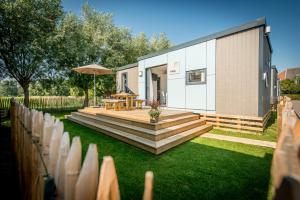 a patio with a table and an umbrella in a yard at Holiday Village Knokke in Knokke-Heist