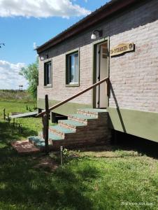 ein Backsteingebäude mit einer Treppe, die zu einer Tür führt in der Unterkunft Wild Wetlands Lodge in Ituzaingó