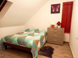 a bedroom with a bed and a dresser at La Chaleureuse crepes et raclettes apres travail in Moissy-Cramayel